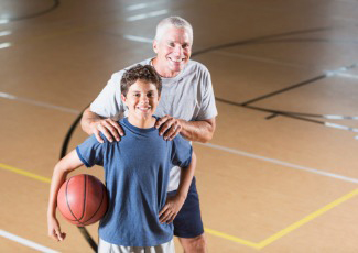 older man and boy playing basketball