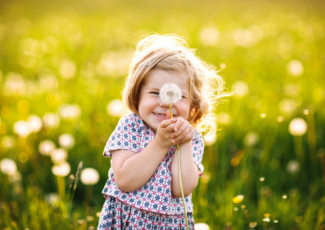 little girl blowing dandelion